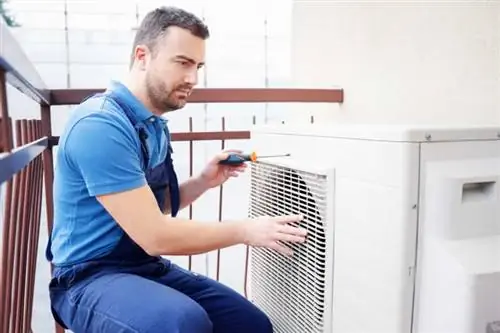 "Техник HVAC проверяет наружный блок переменного тока "Техник HVAC проверяет наружный блок переменного тока