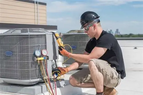 Техник, тестирующий наружную установку HVAC