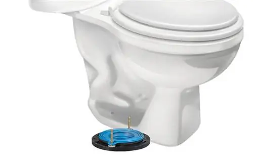 Крупный план белой фарфоровой посуды с резиновым уплотнителем Fluidmaster Better Than Wax на полу. Крупный план белой фарфоровой посуды с резиновым уплотнителем Fluidmaster Better Than Wax на полу.