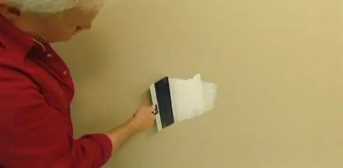 Нанесение шовного герметика на дыру в гипсокартоне.