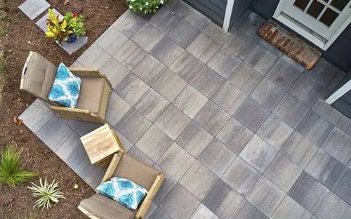 Линейная брусчатка Pavestone Avant, вид сверху на внутренний дворик с двумя шезлонгами.
