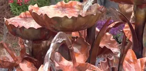 Вода течет из медного фонтана.