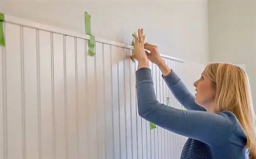 Челси Липфорд Вульф приклеивает малярный скотч к стене