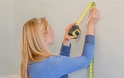 Челси Липфорд Вульф измеряет и отмечает стену