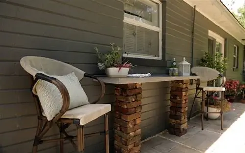 Бетонная столешница во внутреннем дворике со стульями и декором.