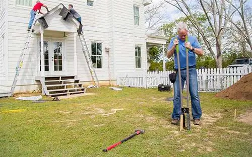Дэнни Липфорд копает землю копателем для столбов.