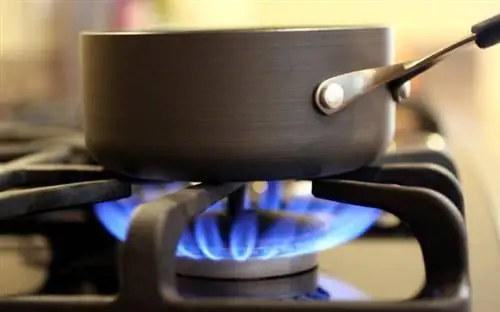 Кастрюля стоит на плите, обогреваемой природным газом.