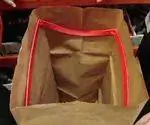 Rubbermaid Roughneck Bag Кость, держащая открытый бумажный пакет.