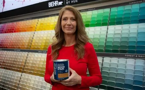 Джоди Маркс держит премиальную быстросохнущую морилку для дерева на водной основе