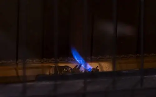 Небольшой пилотный факел для нагревателя газовой печи. Постоянное голубое пламя для розжига основных горелок за защитной решеткой. Комната для копирования.