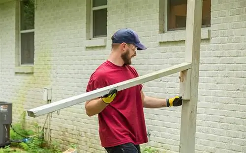 Денвер Хоузи убирает старые перила крыльца с задней части дома