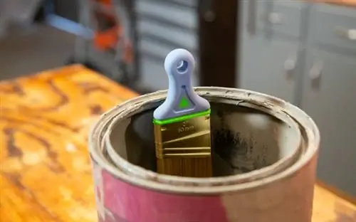 Кисть Wooster Shortcut Hook and Hold Sash Brush, прикрепленная к боку банки с краской.