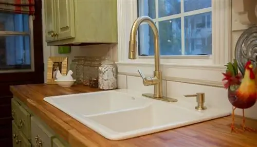 Вид на чугунную раковину с белой эмалью в столешнице мясного блока