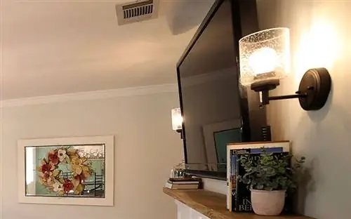 Бра от Kichler Lighting по обеим сторонам телевизора Барбары Криглер над камином.