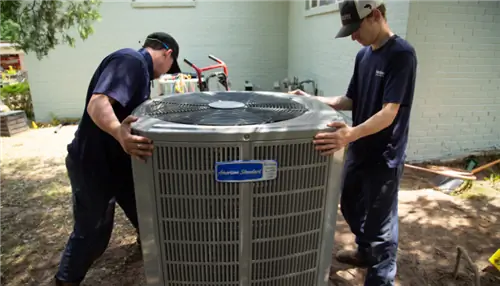 На этом изображении показан кондиционер, устанавливаемый двумя специалистами по HVAC.