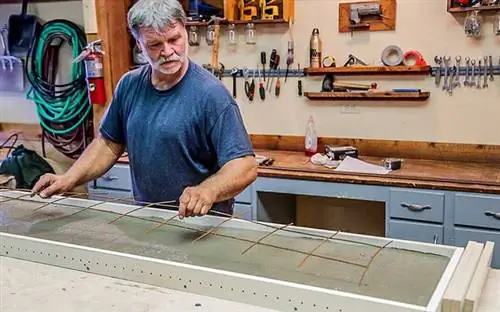 Человек добавляет проволочную сетку для укрепления бетона в форме