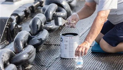 На изображении изображен мужчина на коленях, нарисованный гигантской черной цепью.