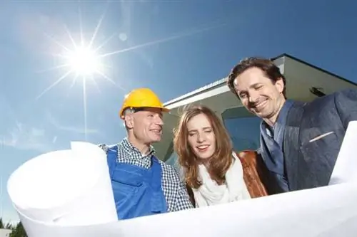 Строитель показывает владельцам планы дизайна дома