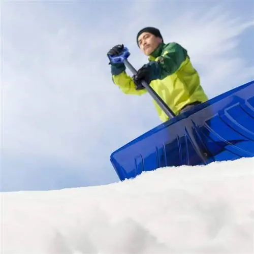 мужчина убирает снег с крыши