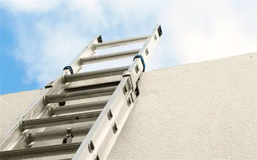 приставная лестница, прислоненная к внешней стене