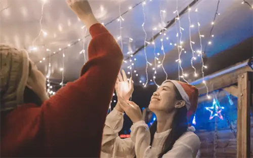 человек улыбается своему праздничному световому дисплею