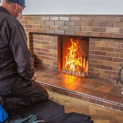 техник, выполняющий осмотр камина