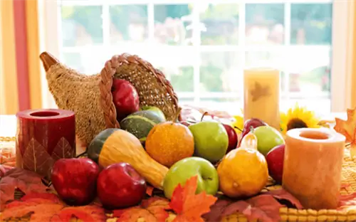 Плетеный рог изобилия в окружении тыкв и яблок