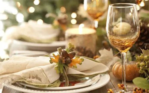 Сервировка стола со стопкой тарелок, ложек и льняной салфетки