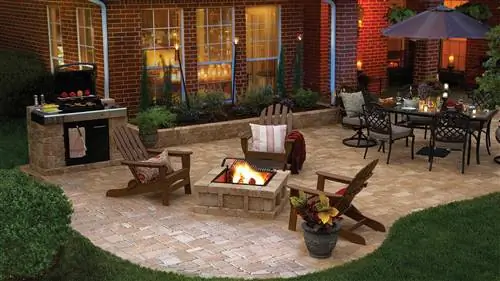 Особенности Hardscape на роскошном заднем дворе с патио, вымощенным брусчаткой, стульями Adirondack и обеденной зоной на открытом воздухе.