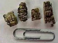 Гранулы вермикулитовой изоляции рядом со скрепкой для накипи