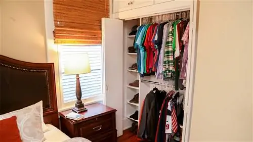 Шкаф в спальне с нишами для обуви и вешалками для рубашек и курток.