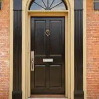 Входная дверь с дверным молотком и прорезью для почты.