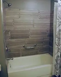 Отделка ванны плиткой со вставками из стеклянной плитки.