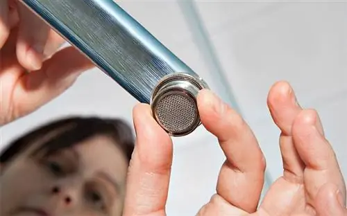 Женщина чистит аэратор кухонного крана