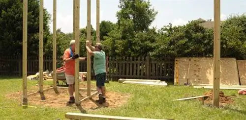 Дэнни и Аллен устанавливают опоры для игровой площадки.