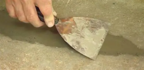 С помощью шпателя выровняйте бетонный участок во внутреннем дворике.