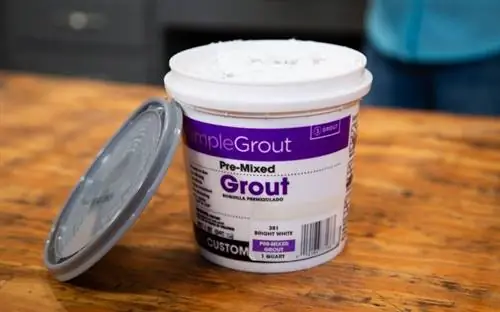 Ванночка SimpleGrout от Custom Building Products, стоящая на деревянном столе в мастерской.