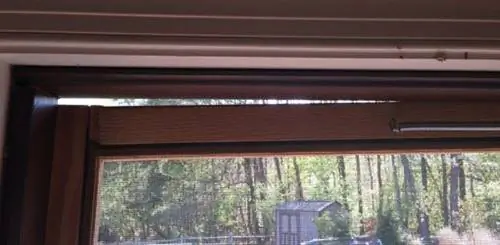 Щель в верхней части провисшей сетчатой двери.