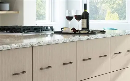 Шкафы в европейском стиле на кухне мечты с двумя бокалами вина на столешнице.