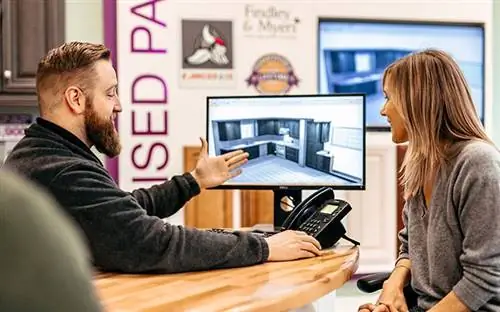 Сотрудник Cabinets to Go помогает покупателю спланировать кухню своей мечты в демонстрационном зале компании