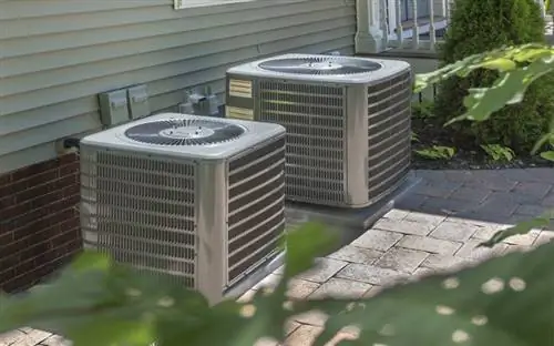 2 кражи системы HVAC, расположенные снаружи дома, с веткой дерева впереди