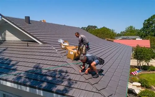 Рабочие стоят на металлической крыше