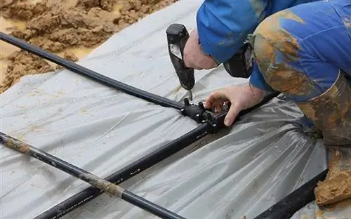 Мужчина устанавливает трубы для геотермального теплового насоса