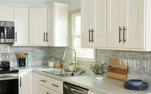 Белые шкафы-шейкеры с великолепными черными ручками на современной кухне