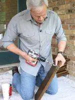 Дэнни Липфорд меняет петли на дверцах шкафов.