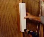 Прикручивание водосточной трубы к стене в магазине.