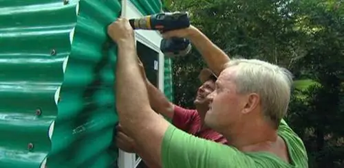 Крепление штормовой двери к теплице с помощью шурупов.