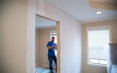 Джон из Danny Lipford Construction отделывает гипсокартоном ненесущую стену.