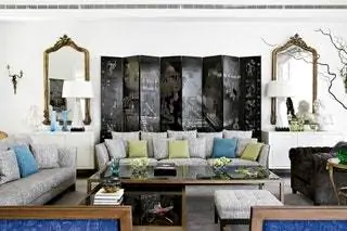 На заднем плане китайская лакированная ширма 19-го века, елизаветинские зеркала из сусального золота и бра из бронзы в стиле Людовика XV, все в анмодере…