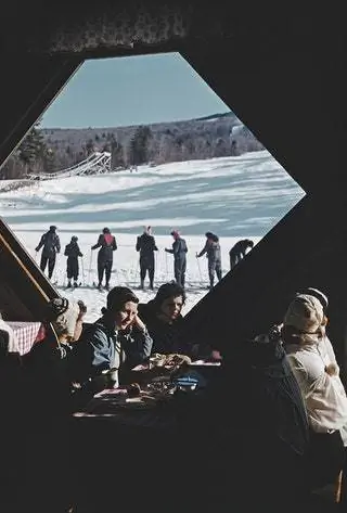 На склонах горы Крэнмор, роскошного курорта в Нью-Гэмпшире, лыжники отдыхают…